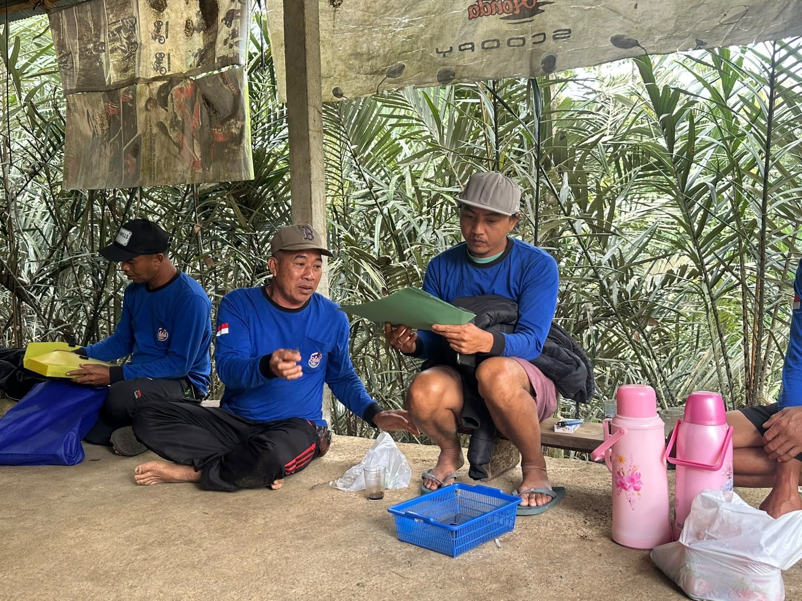 Tiga anggota kelompok tani salak berdiskusi sambil menikmati kopi